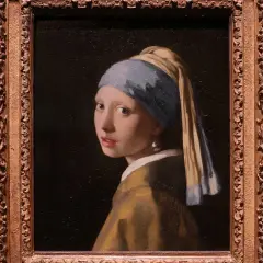 Dama z perłą, młoda kobieta w turbanie i żółtej szacie, spogląda przez ramię. Jej spojrzenie jest hipnotyzujące, a jedyna ozdoba to duża perła.