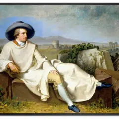 Johann Wolfgang von Goethe w białej szacie i szerokim kapeluszu, siedzący na kamieniach. W tle krajobraz z ruinami, inspiracja dla jego dzieł.