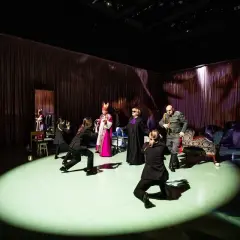 Scena teatralna z postaciami w strojach historycznych i współczesnych. Czy tyle jest teatrów w Warszawie, ile postaci na scenie?