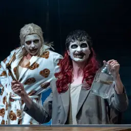 Dwie postacie z makijażem w stylu klauna, jedna w szlafroku w misie, druga z butelką. Czy to scena z "Ubu Król"?