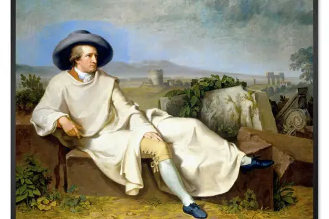 Johann Wolfgang von Goethe w białej szacie i szerokim kapeluszu, siedzący na kamieniach. W tle krajobraz z ruinami, inspiracja dla jego dzieł.