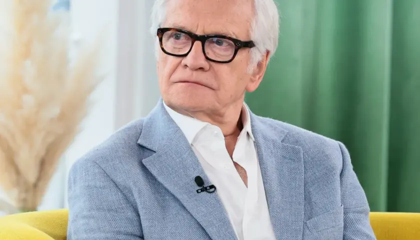 Andrzej Seweryn, znany z bogatego pochodzenia artystycznego, w jasnej marynarce i okularach.