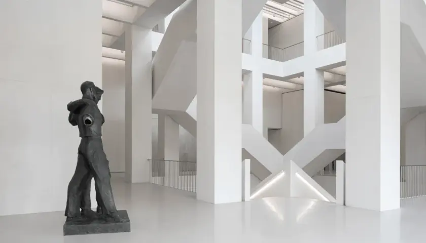 Rzeźba w nowoczesnym muzeum z betonową architekturą i schodami.
