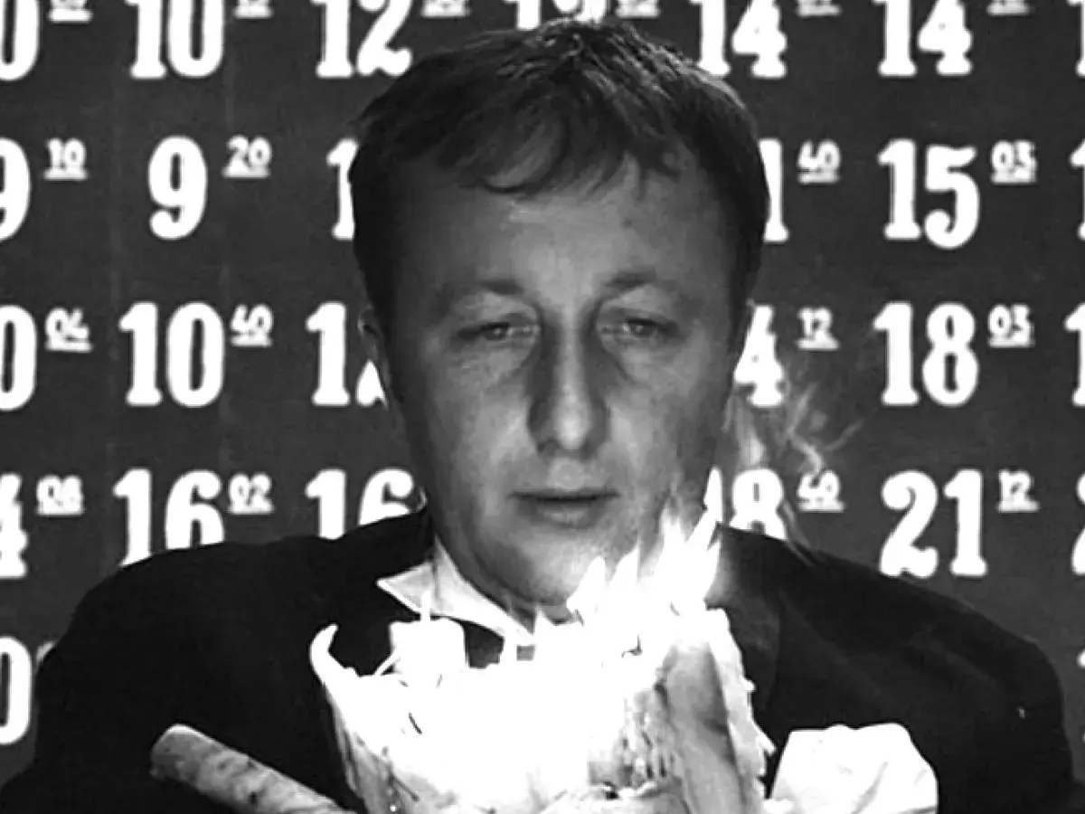 Mężczyzna w garniturze trzyma płonące świece. Tło to liczby, jakby czas się zatrzymał, symbolizując cenzurę i przemijanie.