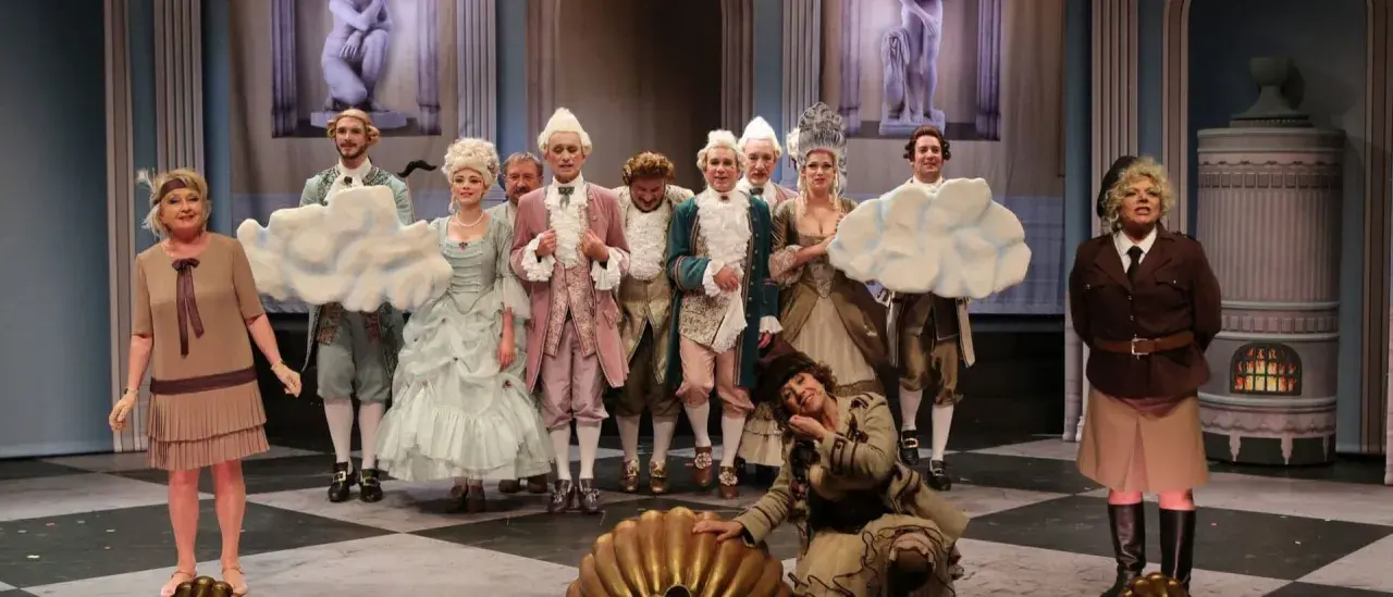 Piękna Lucynda w teatrze na 6. piętrze, w otoczeniu aktorów w strojach z epoki, przygotowuje się do spektaklu.