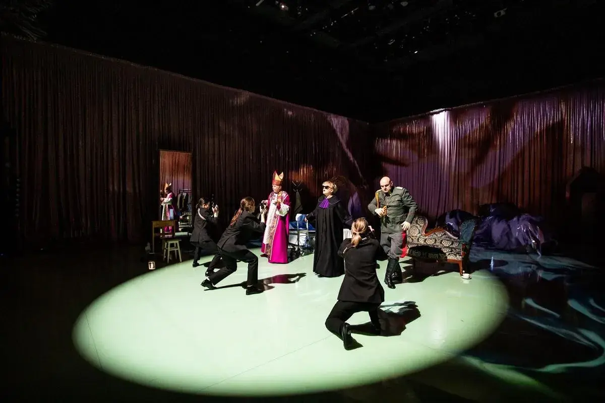 Scena teatralna z postaciami w strojach historycznych i współczesnych. Czy tyle jest teatrów w Warszawie, ile postaci na scenie?