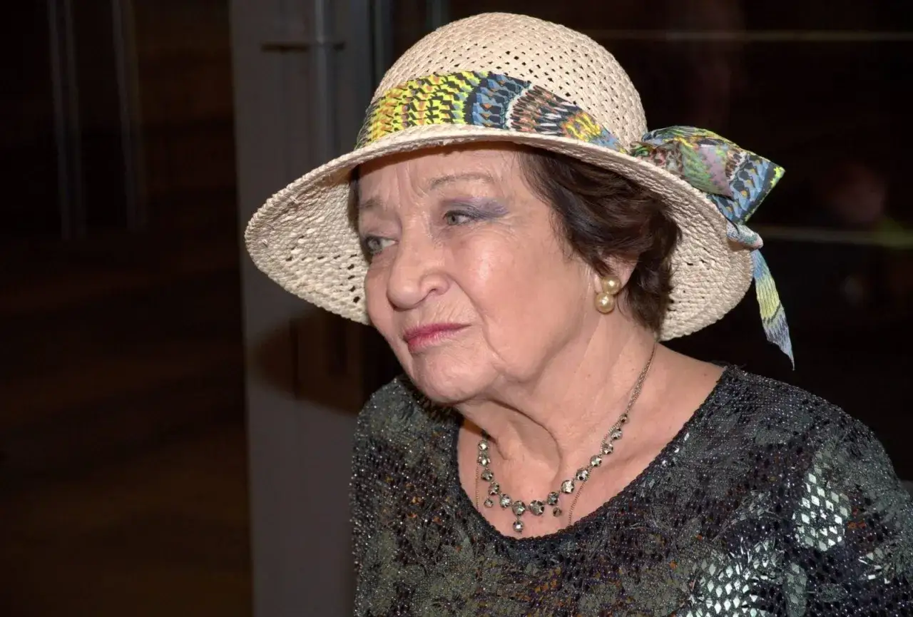 Elegancka Ewa Dałkowska w słomkowym kapeluszu z kolorową wstążką. Wiek dodaje jej uroku.